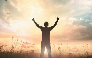 silhouette of a man with arms raised in victory