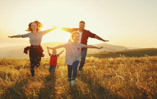 a family having fun together in a field at sunset